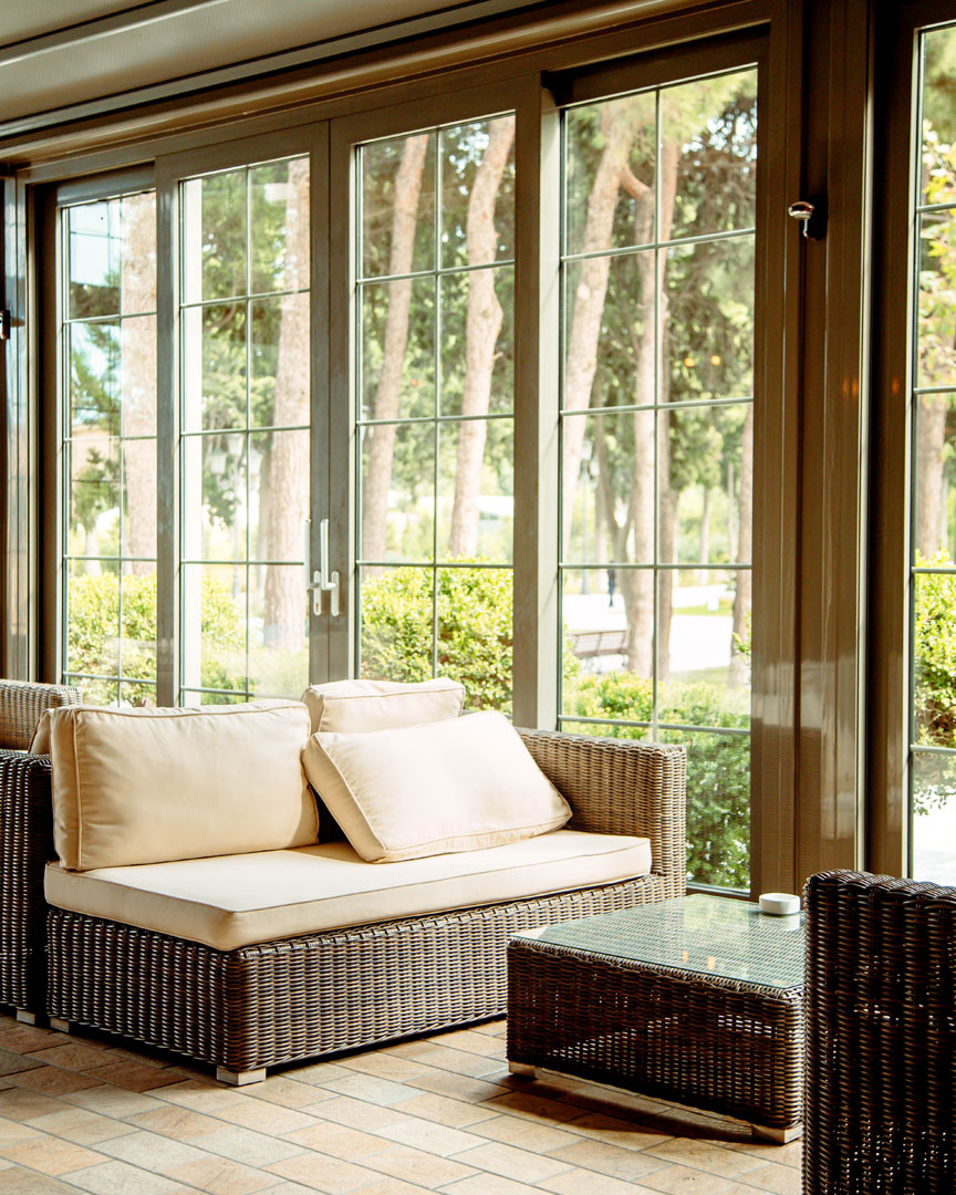 outdoor sofa with beige cushions and coffee table in front of the restaurant window