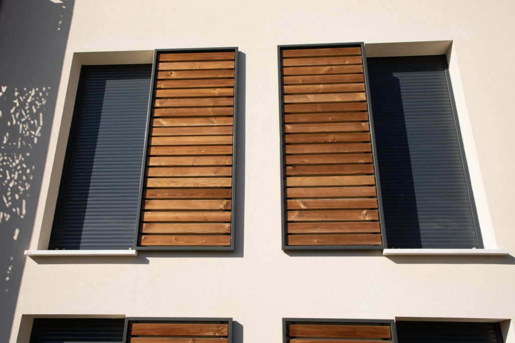 home windows with modern wooden brown sliding shutters in house